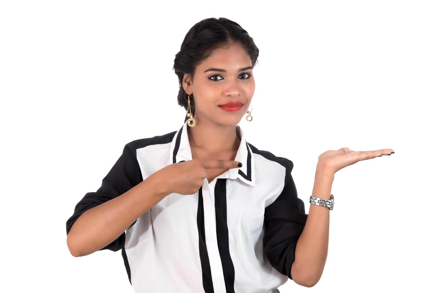 Beautiful girl holding and presenting something in the hand with happy smiling. photo