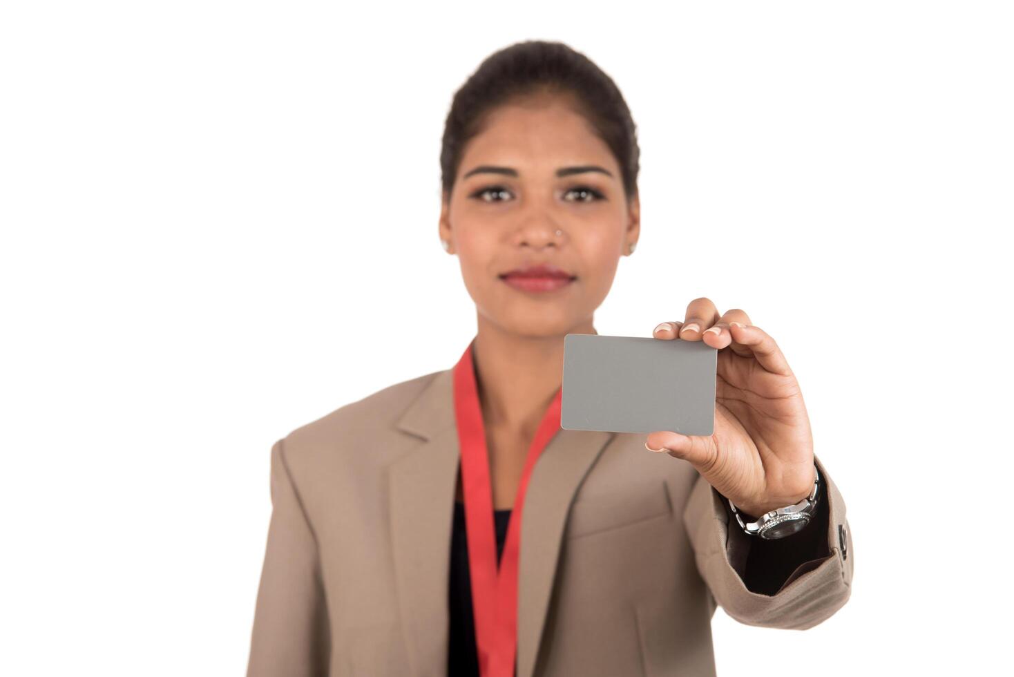 Smiling business woman holding a blank business card or ID card over white background photo