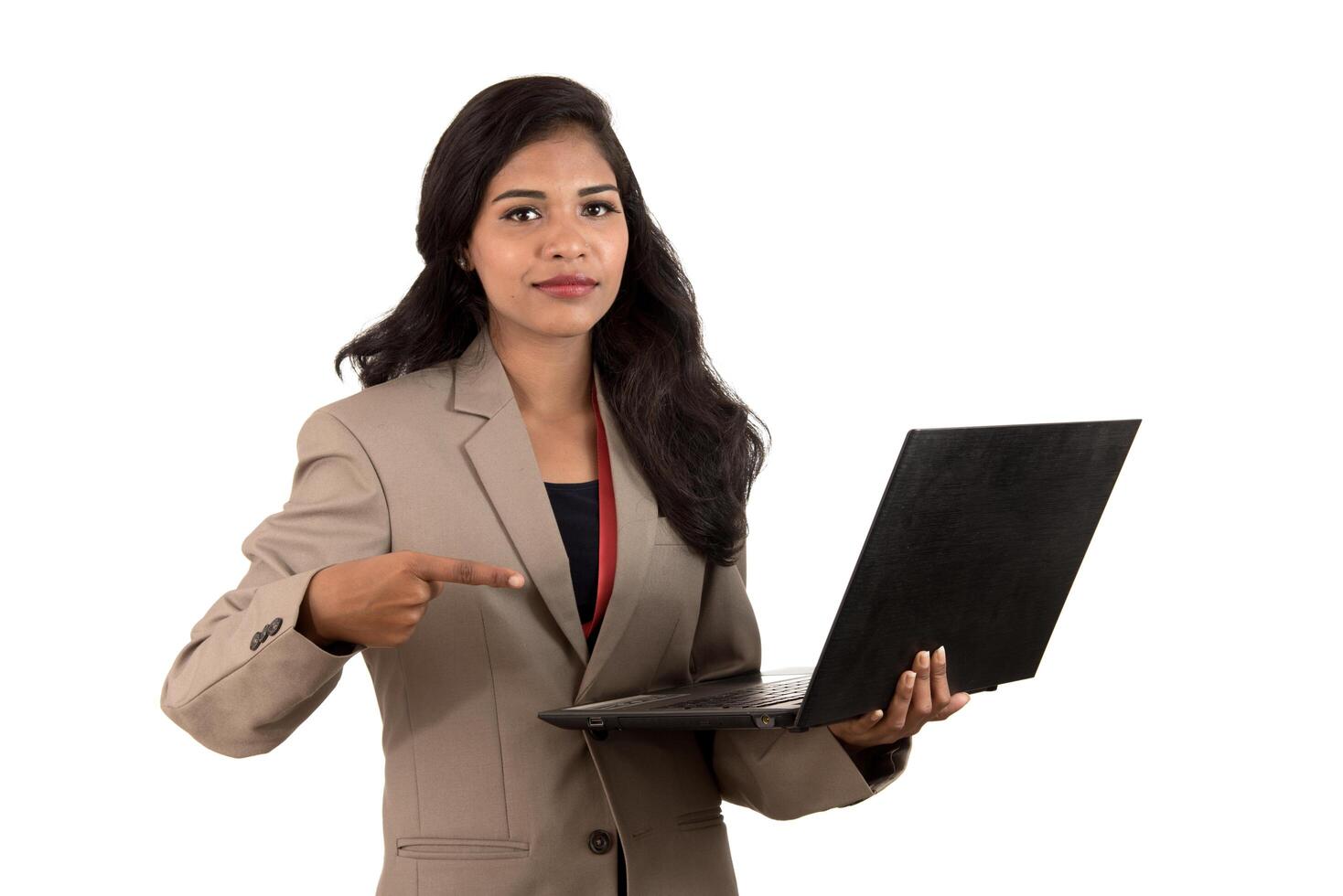 Happy excited business woman holding laptop and pointing on it isolated on a white background photo