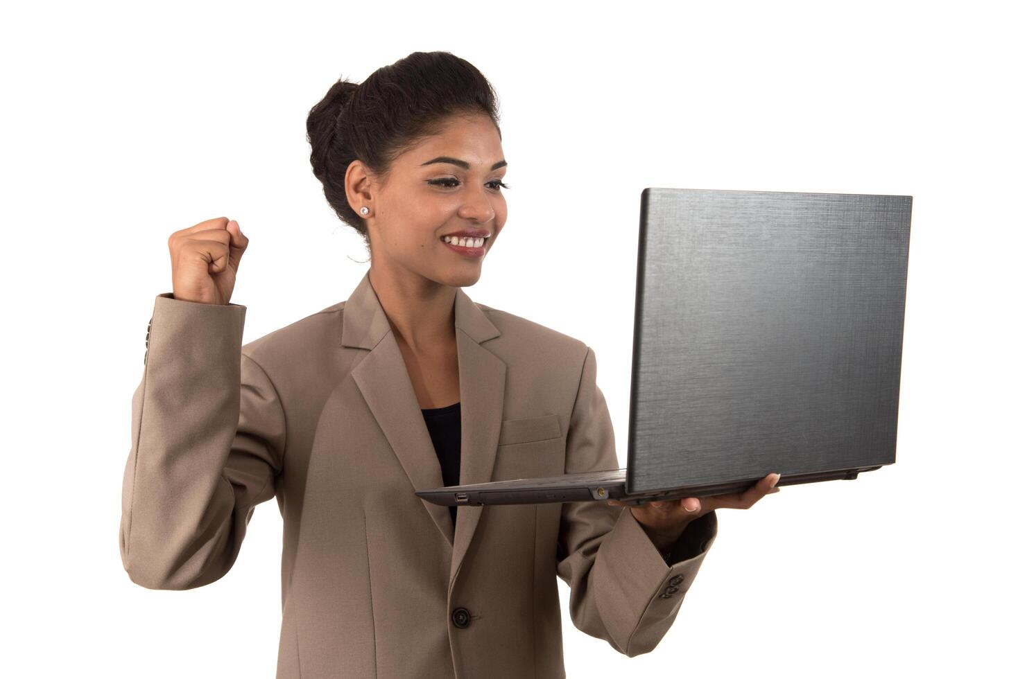 young woman holding a laptop while showing victory sign. isolated on white background photo