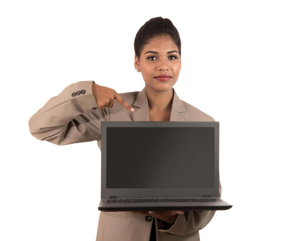 Happy excited business woman holding laptop and pointing on it isolated on a white background photo