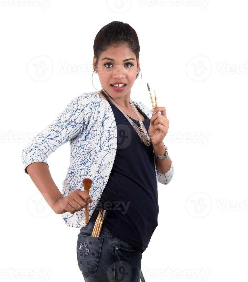 Beautiful young girl enjoying with makeup brushes isolated on white photo