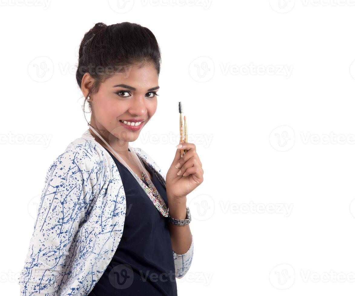 Beautiful young girl enjoying with makeup brushes isolated on white photo