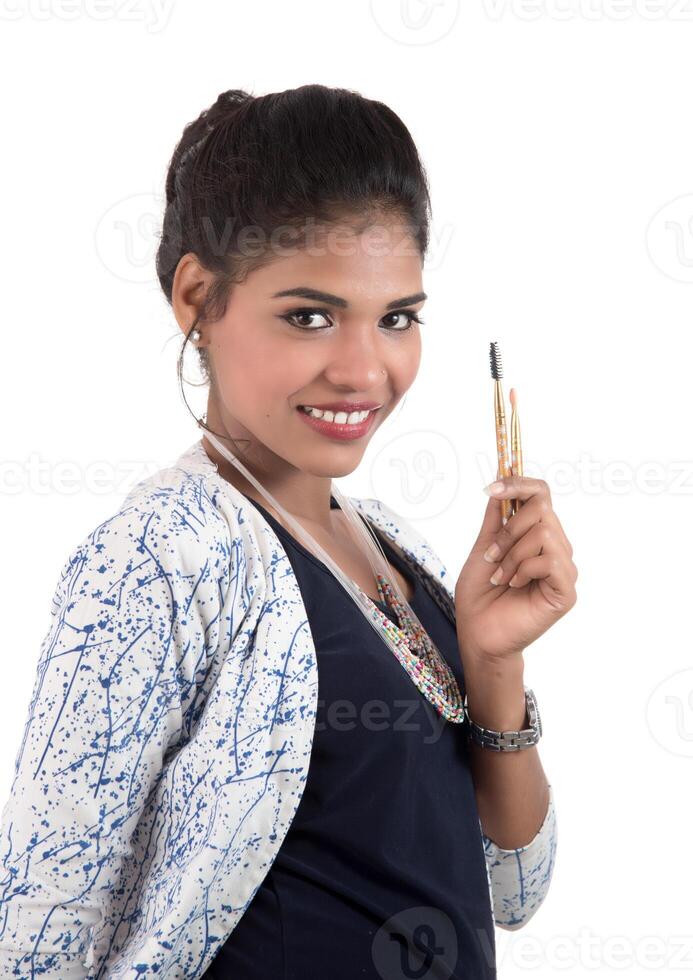 Beautiful young girl enjoying with makeup brushes isolated on white photo