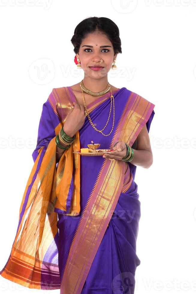 Indian woman performing worship, portrait of a beautiful young lady with pooja thali isolated on white background photo
