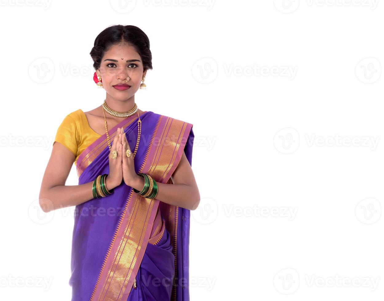 Young Indian girl in traditional clothing greeting namaste, Welcome, Indian girl in a tradition sari with welcome expression inviting photo
