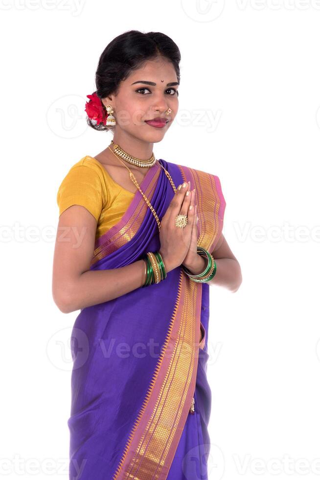 Young Indian girl in traditional clothing greeting namaste, Welcome, Indian girl in a tradition sari with welcome expression inviting photo