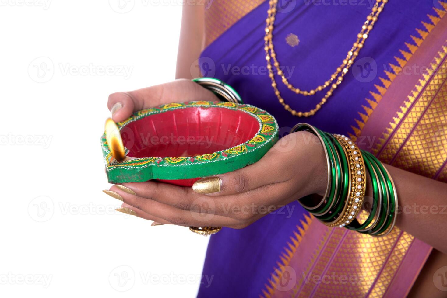 Portrait of a woman holding diya, Diwali or deepavali photo with female hands holding oil lamp during festival of light on white background