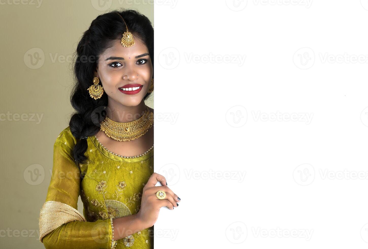 Traditional Girl holding and showing blank white sign board photo