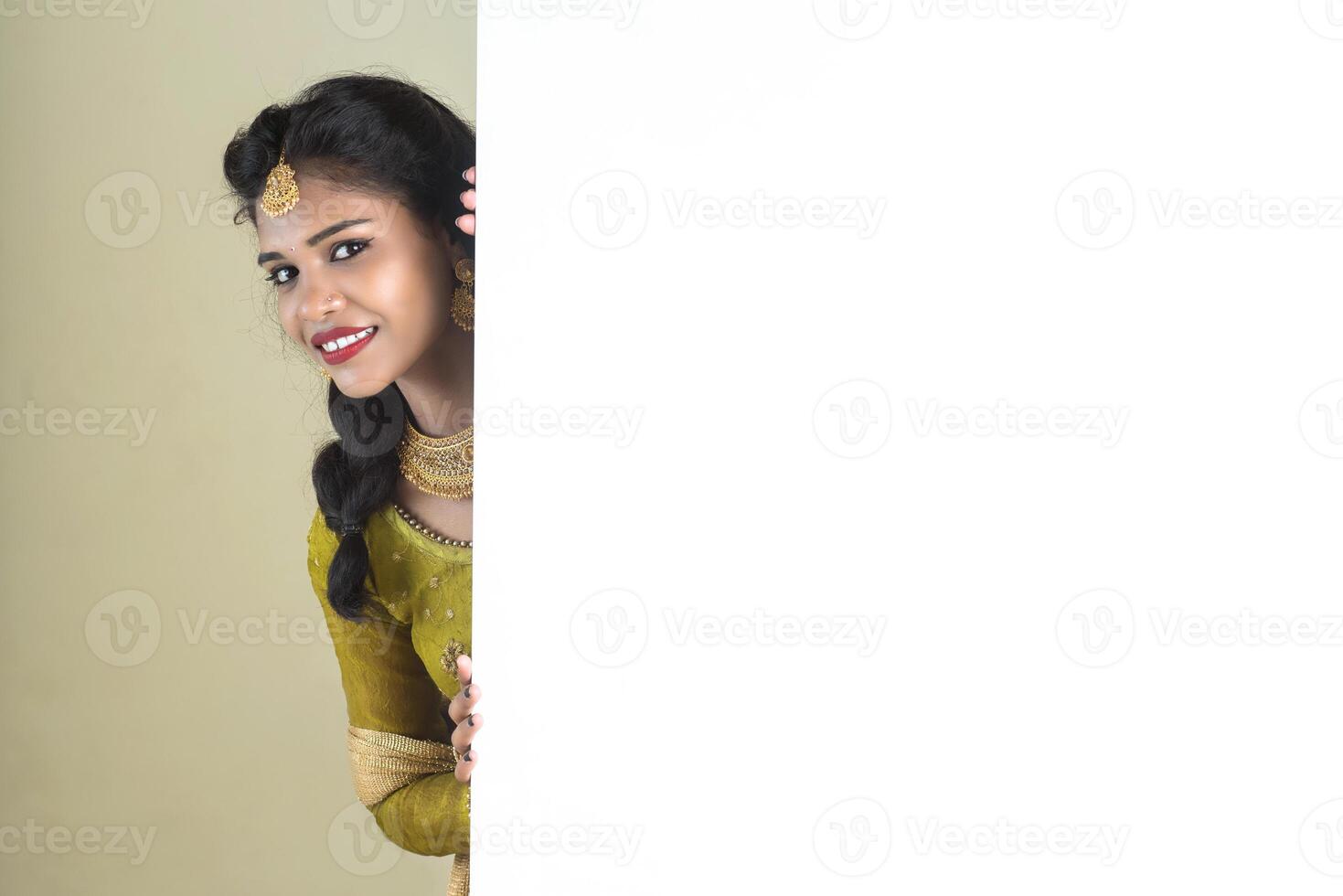 Traditional Girl holding and showing blank white sign board photo