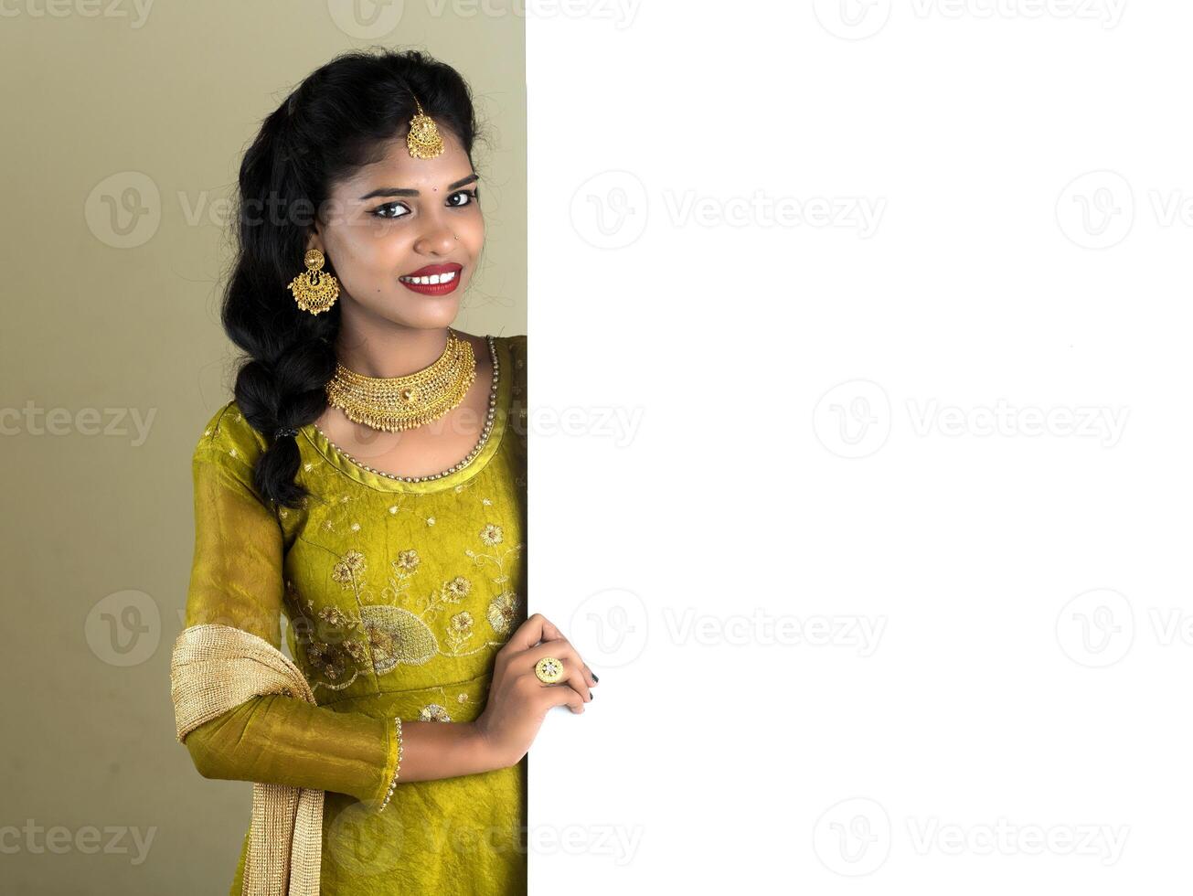 Traditional Girl holding and showing blank white sign board photo