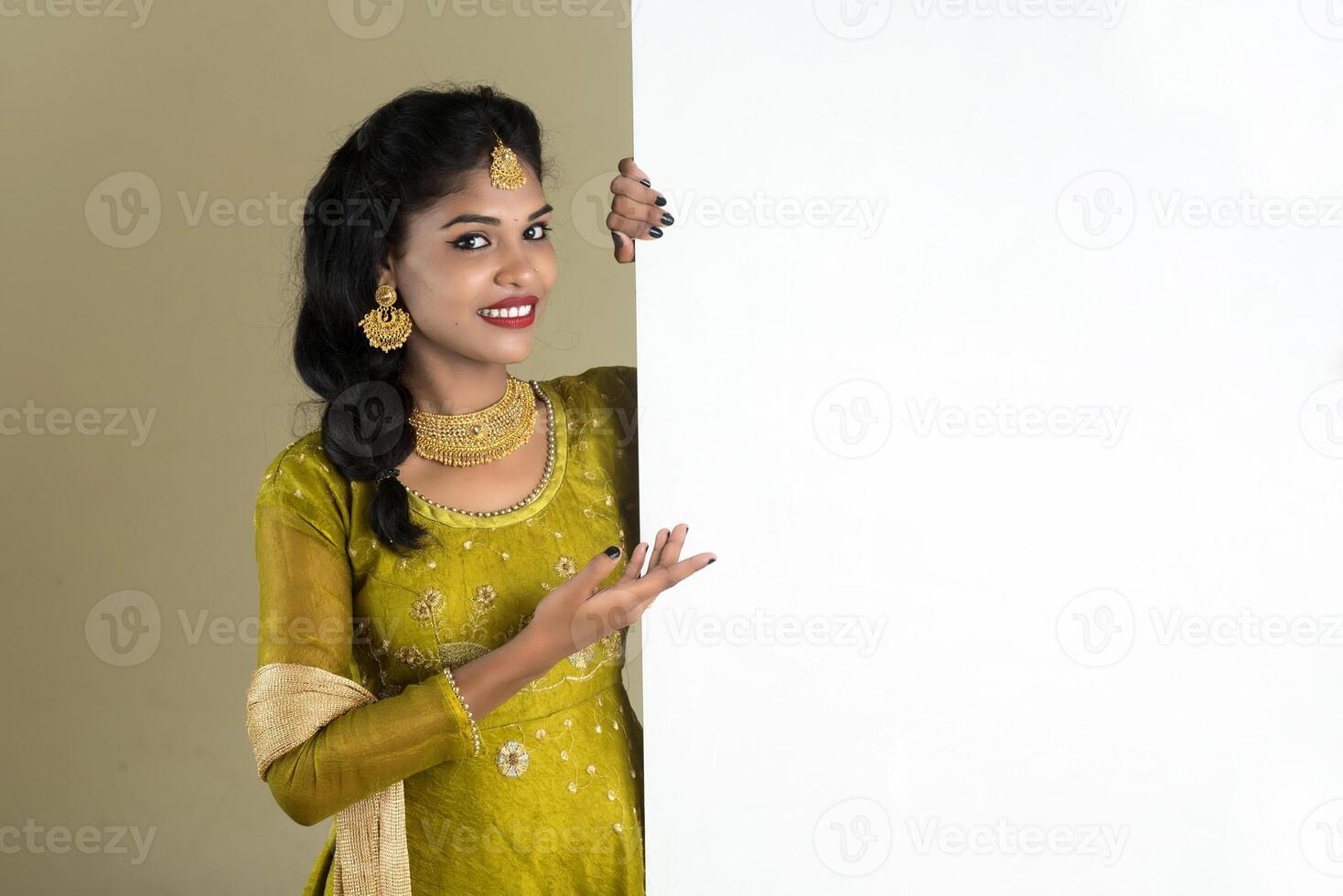 Traditional Girl holding and showing blank white sign board photo