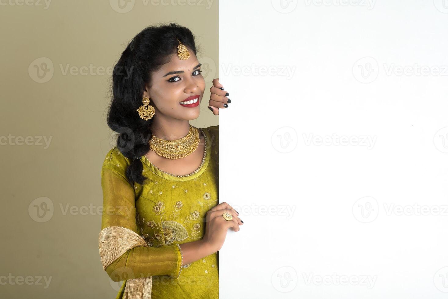 Traditional Girl holding and showing blank white sign board photo