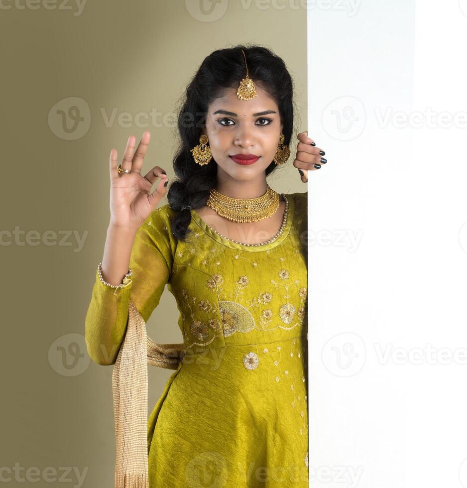 Traditional Girl holding and showing blank white sign board photo