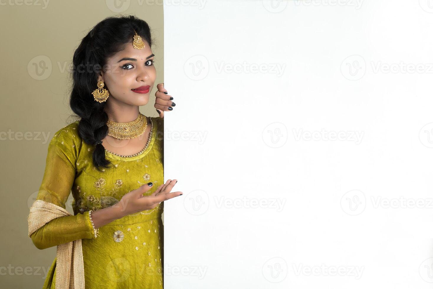 Traditional Girl holding and showing blank white sign board photo
