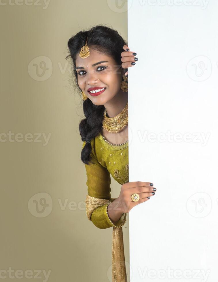 Traditional Girl holding and showing blank white sign board photo