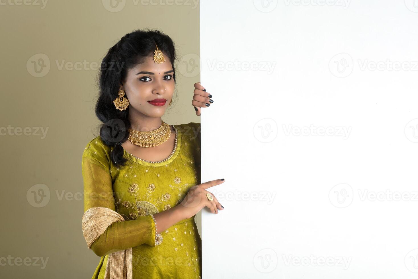 Traditional Girl holding and showing blank white sign board photo