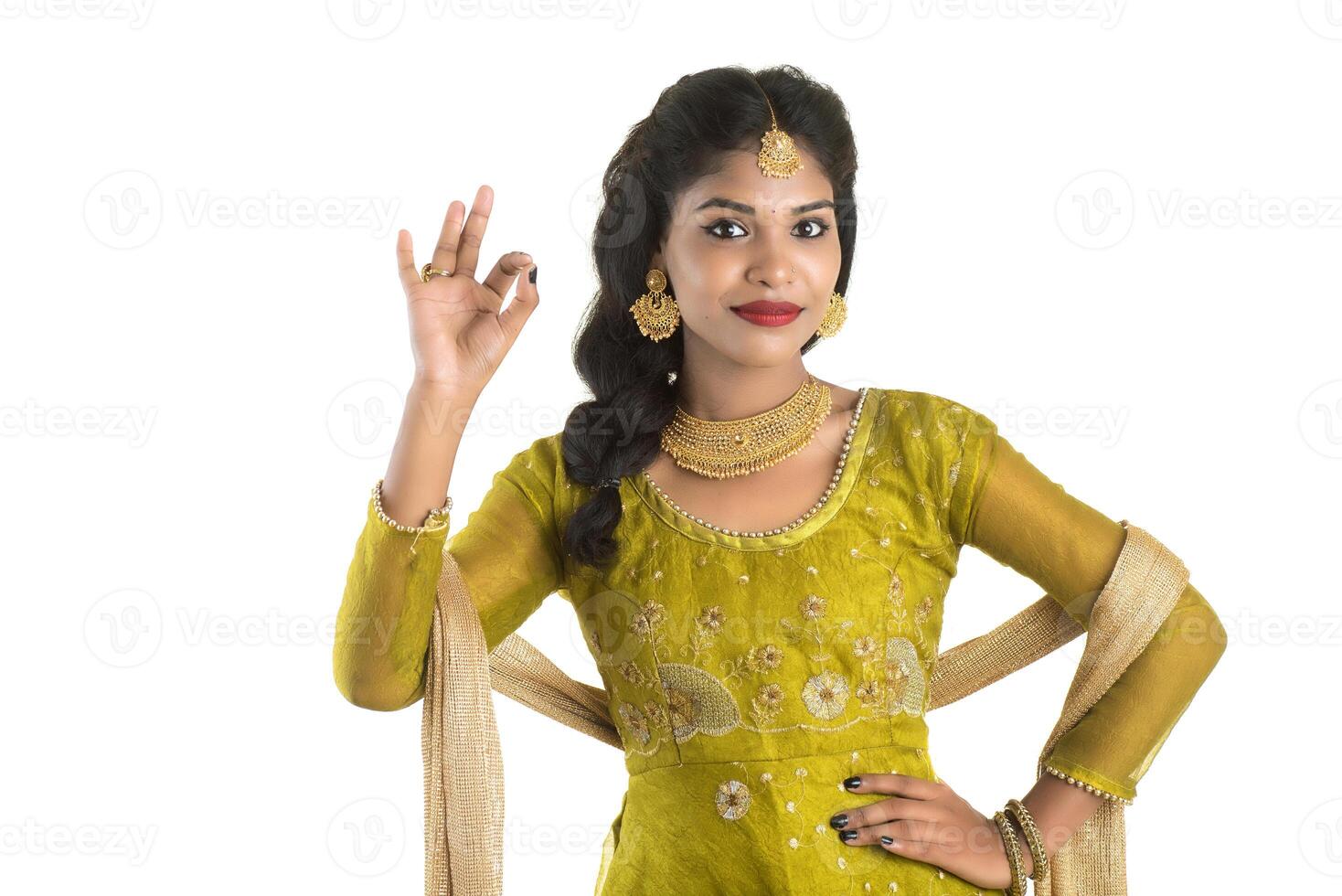 Smiling cheerful girl showing sign isolated on white background photo