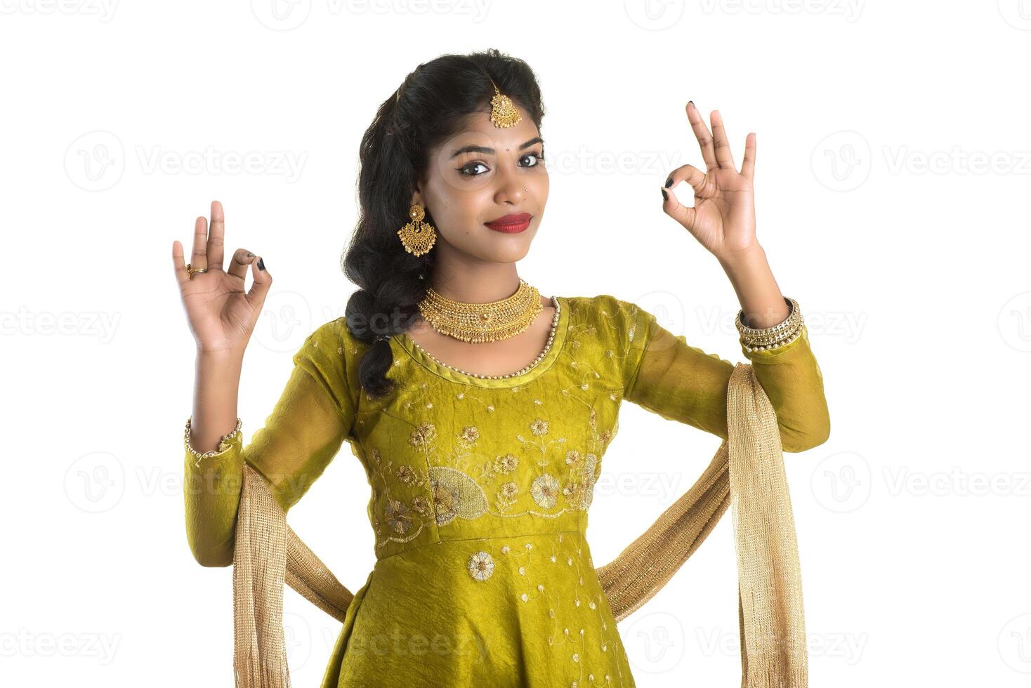 Smiling cheerful girl showing sign isolated on white background photo