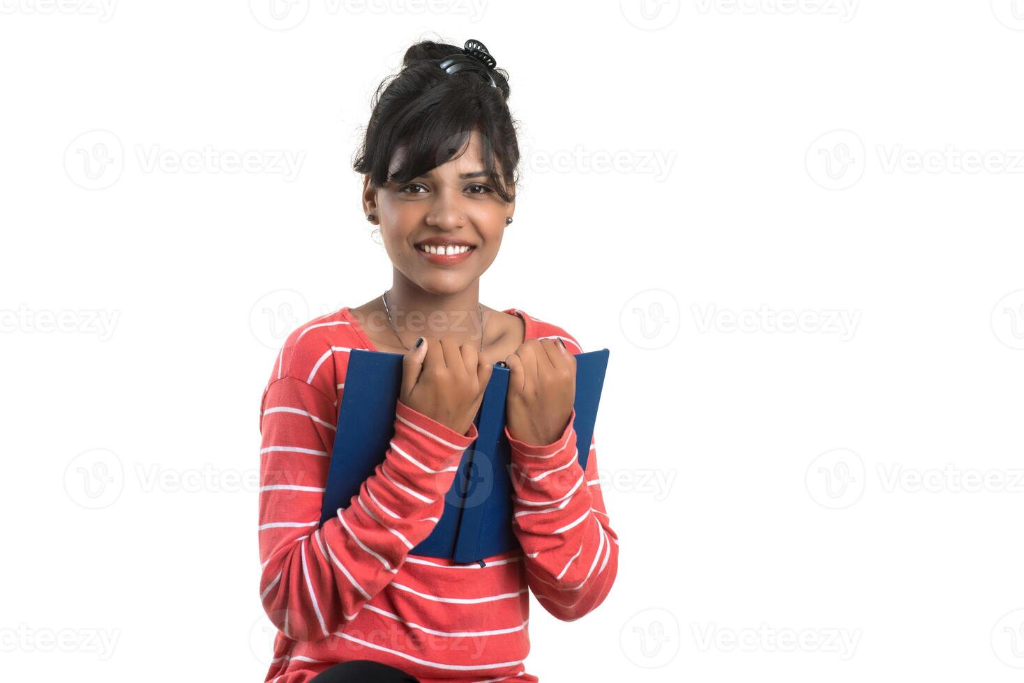 Pretty young girl holding book and posing on white background photo