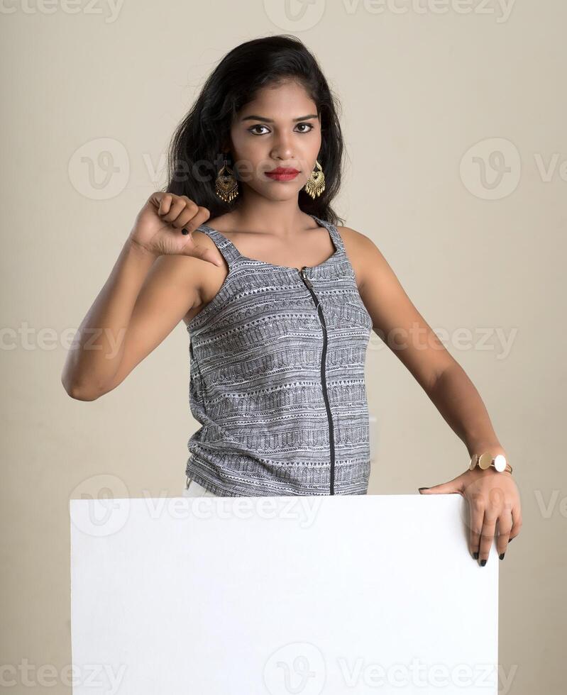 Beautiful young Girl holding white big signboard and posing photo