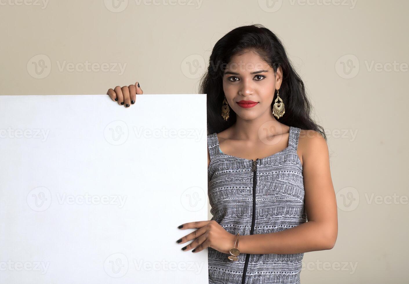 Beautiful young Girl holding white big signboard and posing photo