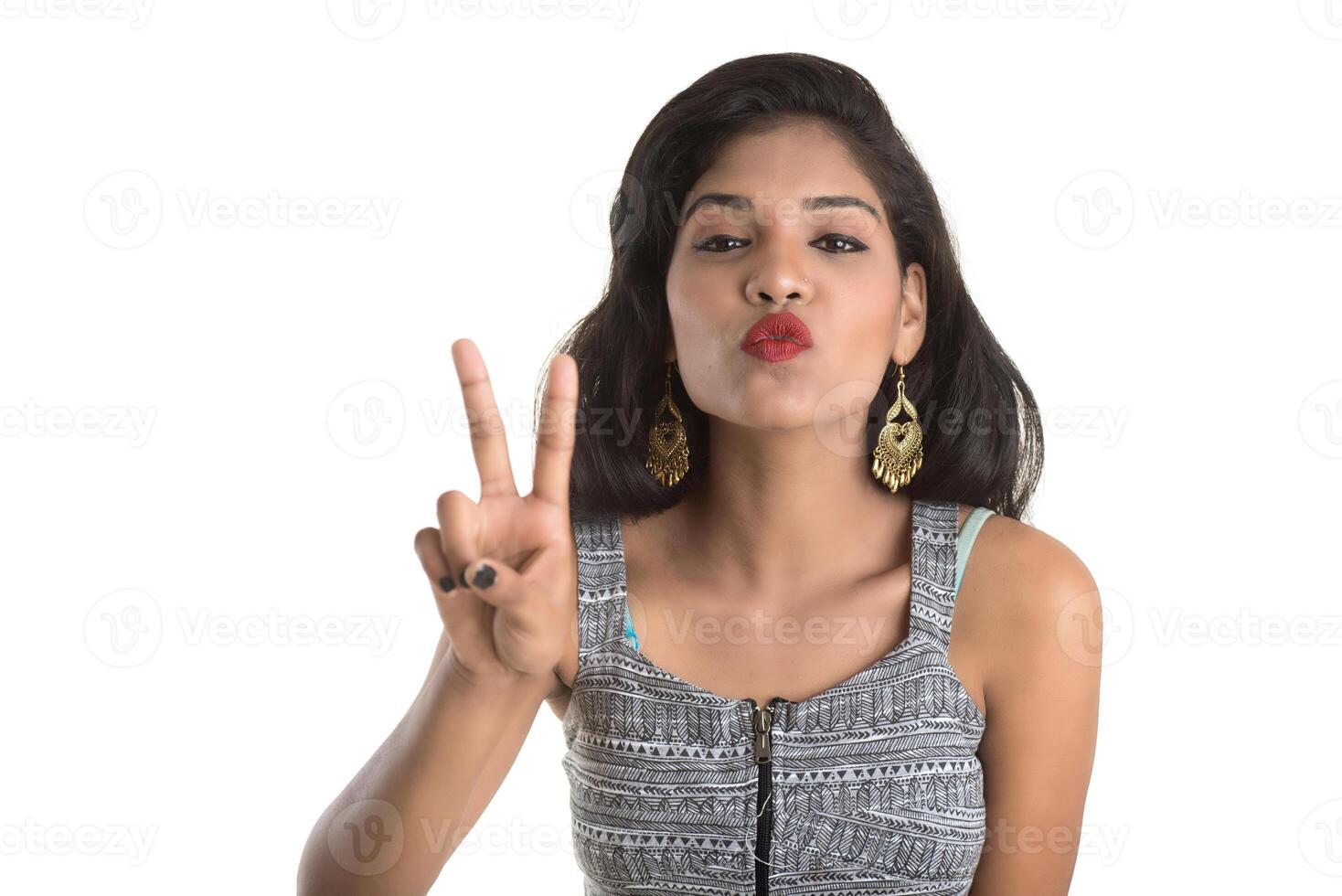 Smiling cheerful girl showing sign isolated on white background photo