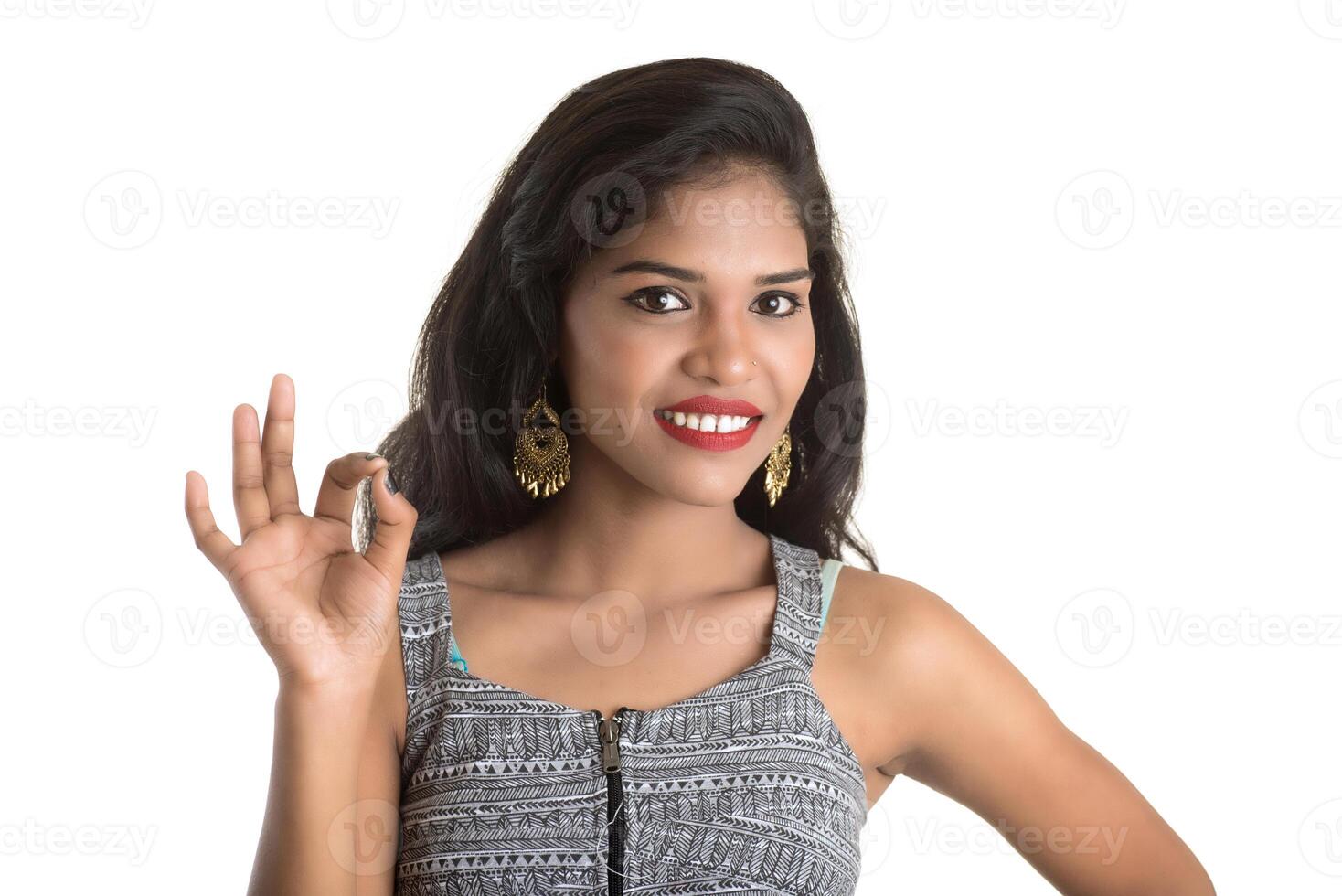 Smiling cheerful girl showing sign isolated on white background photo
