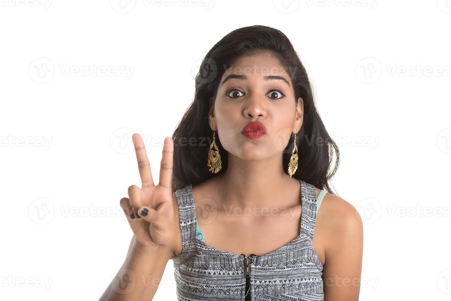 Smiling cheerful girl showing sign isolated on white background photo
