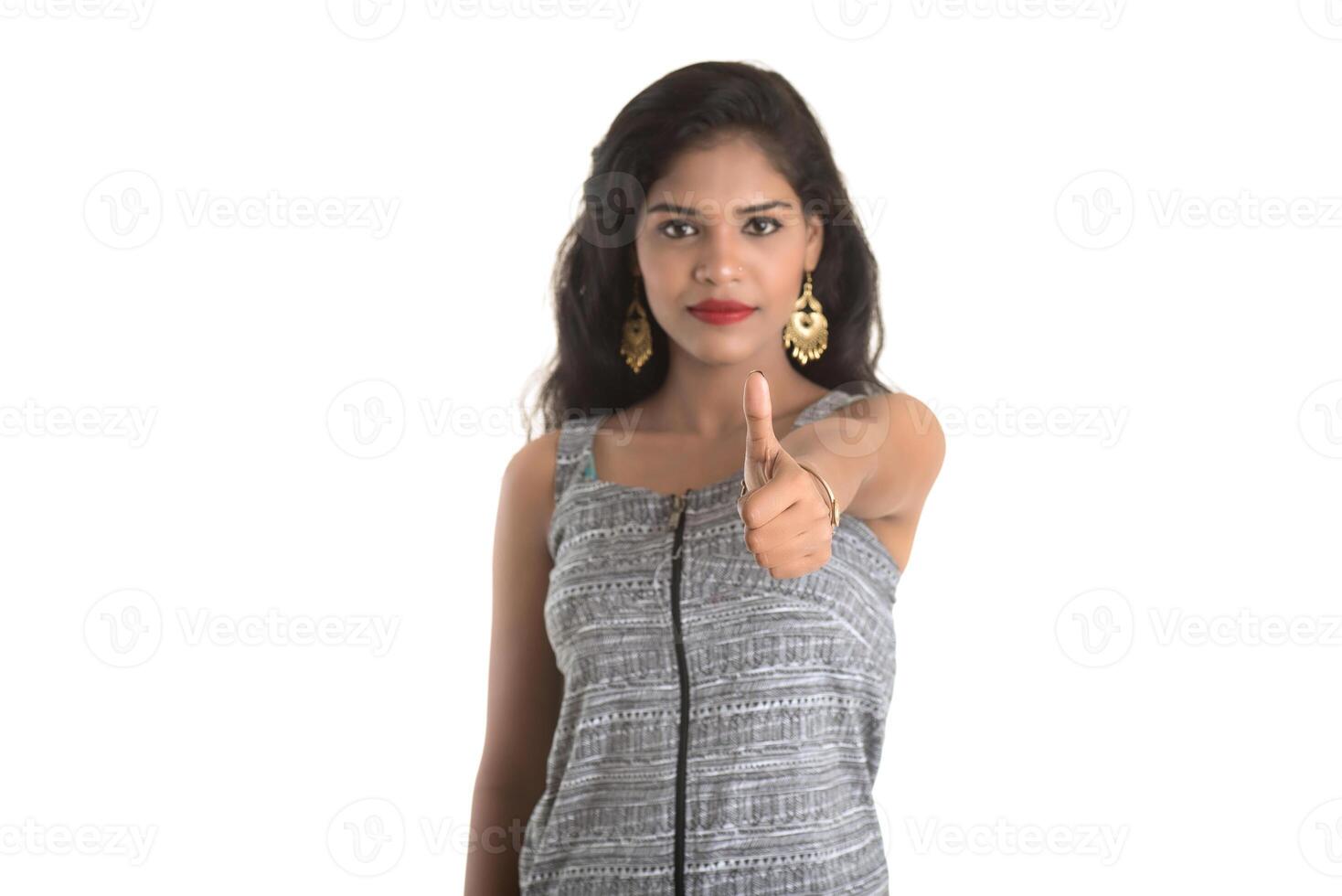 Smiling cheerful girl showing sign isolated on white background photo