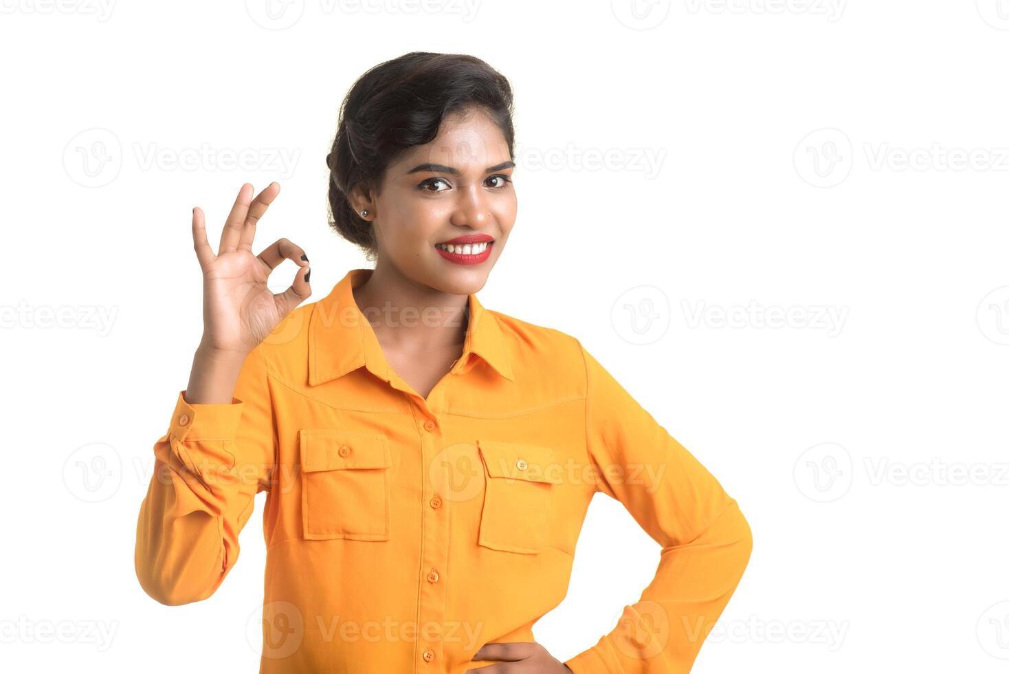 Smiling cheerful girl showing sign isolated on white background photo