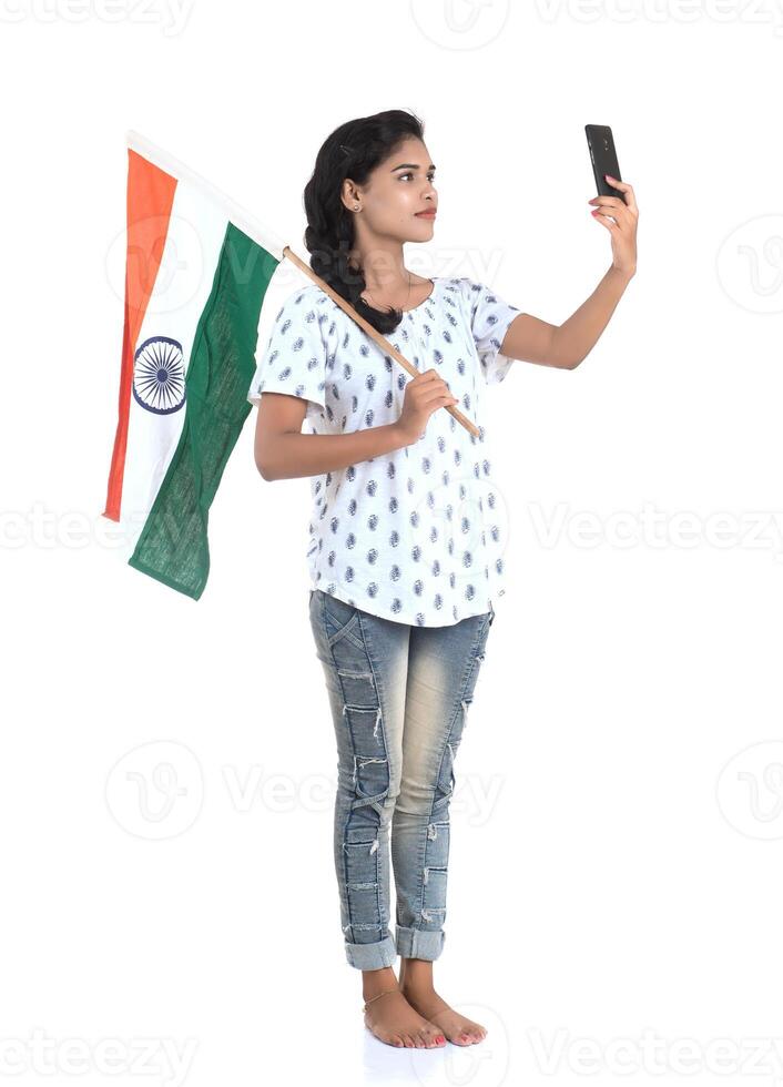 Girl using mobile with Indian flag or tricolour on white background, Indian Independence day, Indian Republic day photo