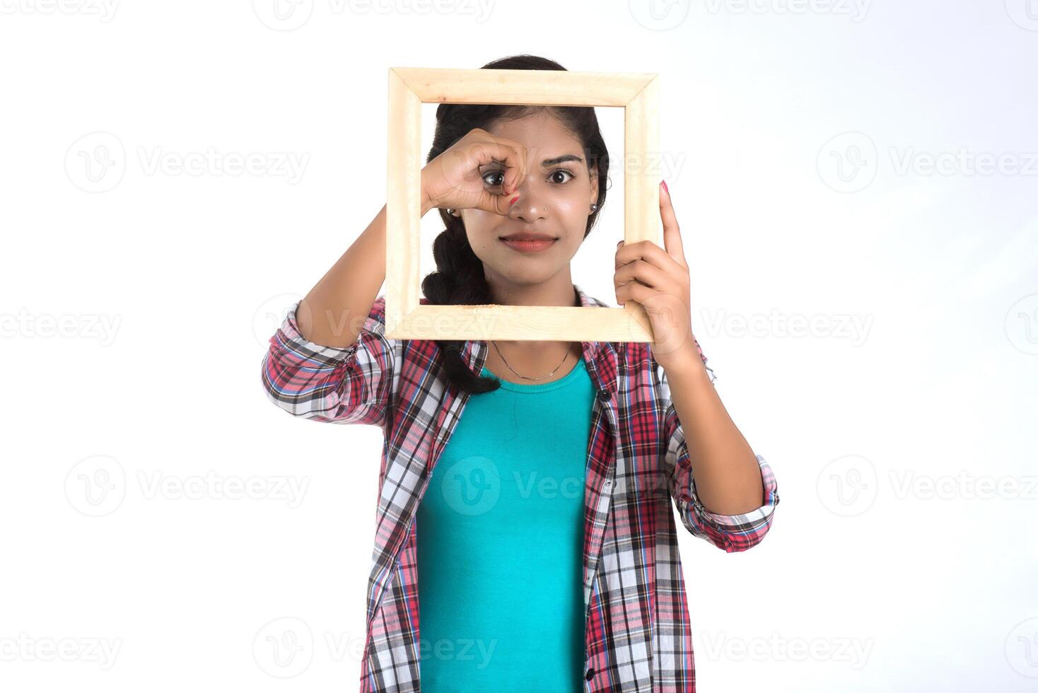 attractive young woman holding and posing with Picture frame on a white background. photo