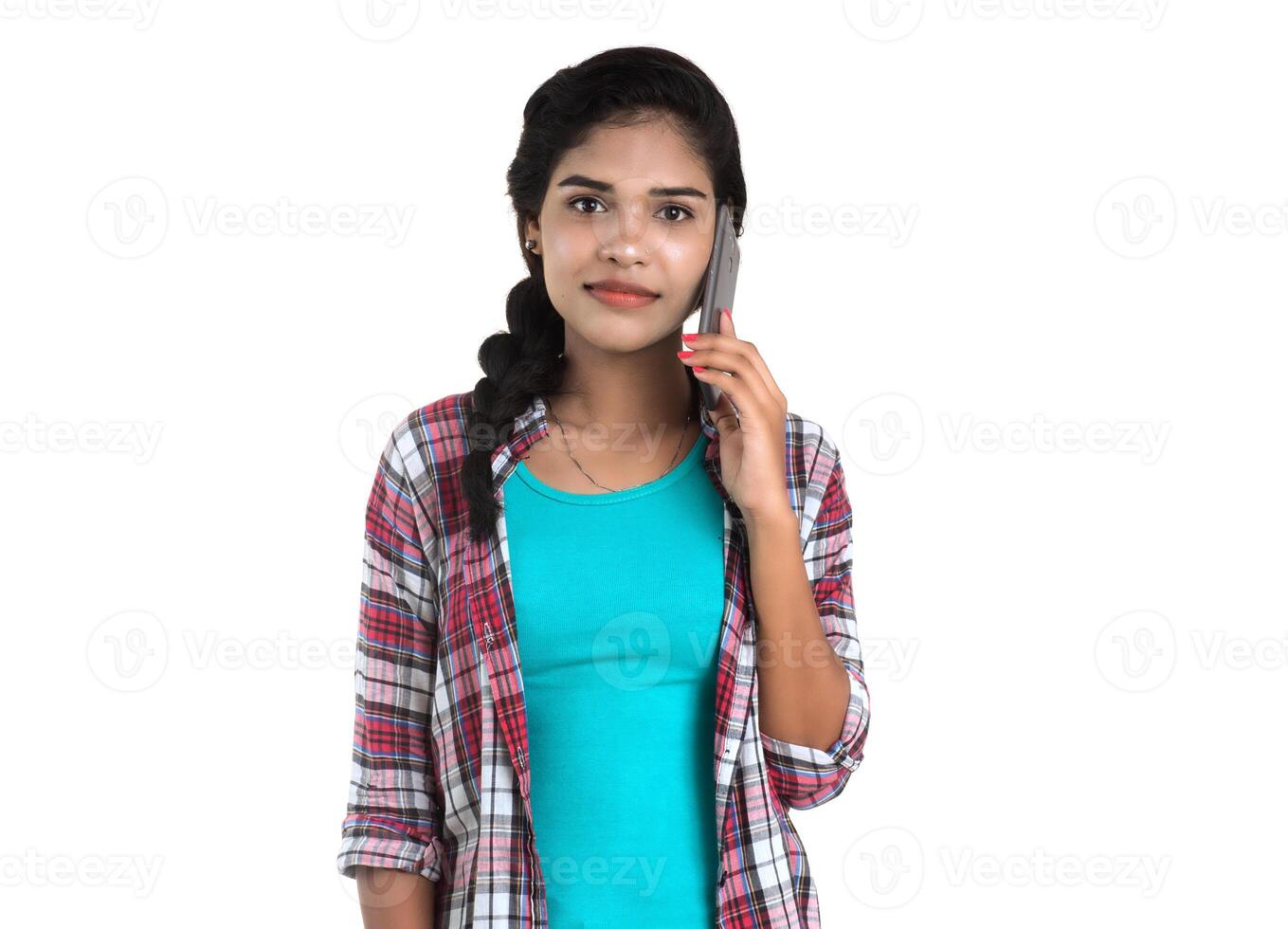 Young Indian girl using a mobile phone or smartphone isolated on a white background photo