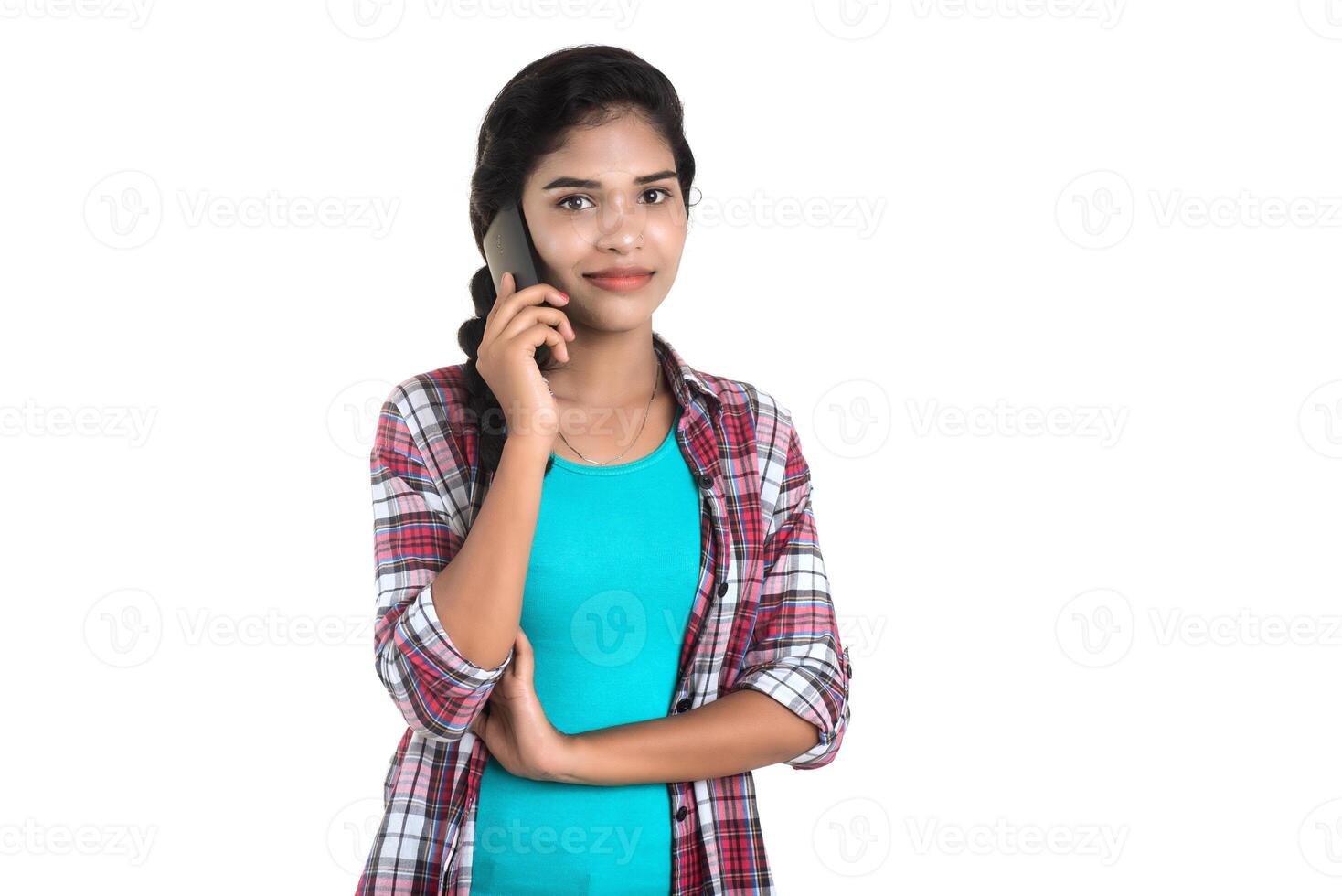 Young Indian girl using a mobile phone or smartphone isolated on a white background photo