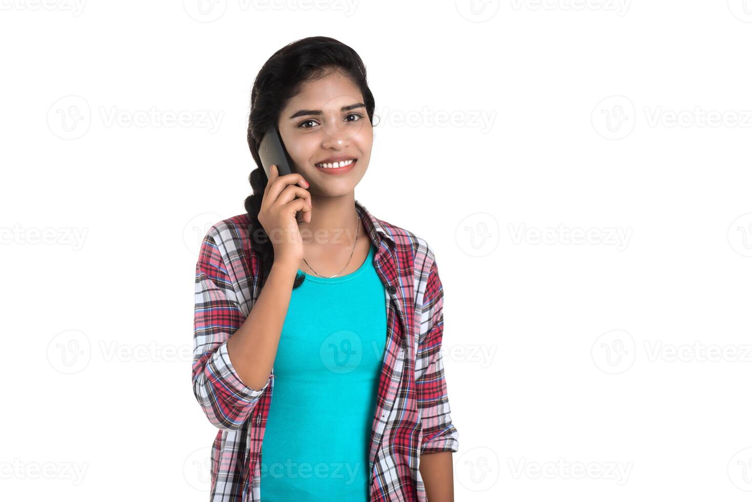 Young Indian girl using a mobile phone or smartphone isolated on a white background photo