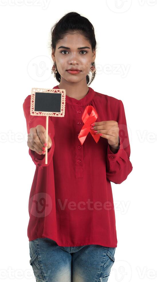 Young woman showing red ribbon HIV, AIDS awareness ribbon, healthcare and medicine concept photo