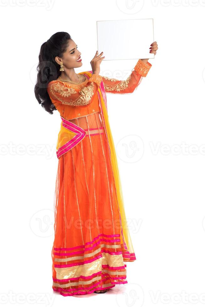 Traditional Girl holding and showing blank white sign board photo