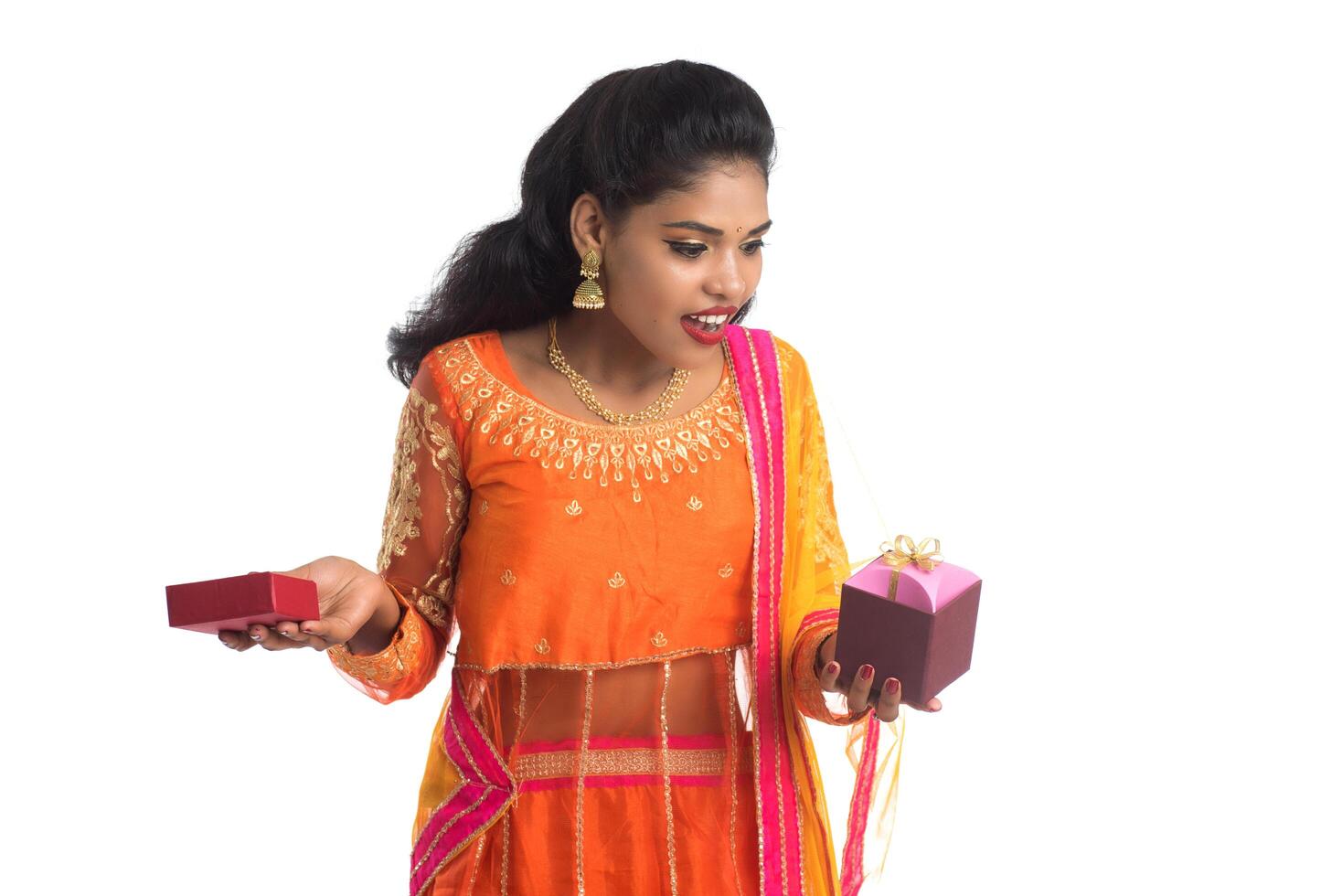 Portrait of young happy smiling Indian Girl holding gift boxes on a white background. photo