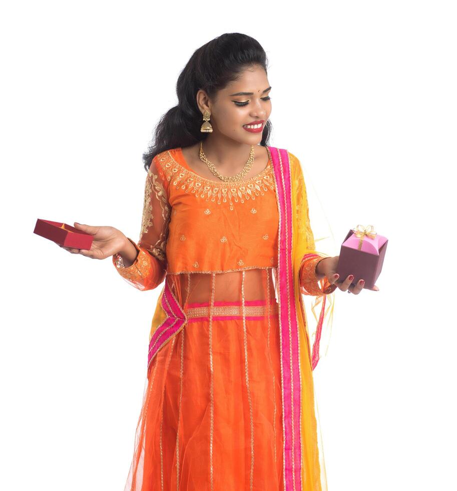 Portrait of young happy smiling Indian Girl holding gift boxes on a white background. photo