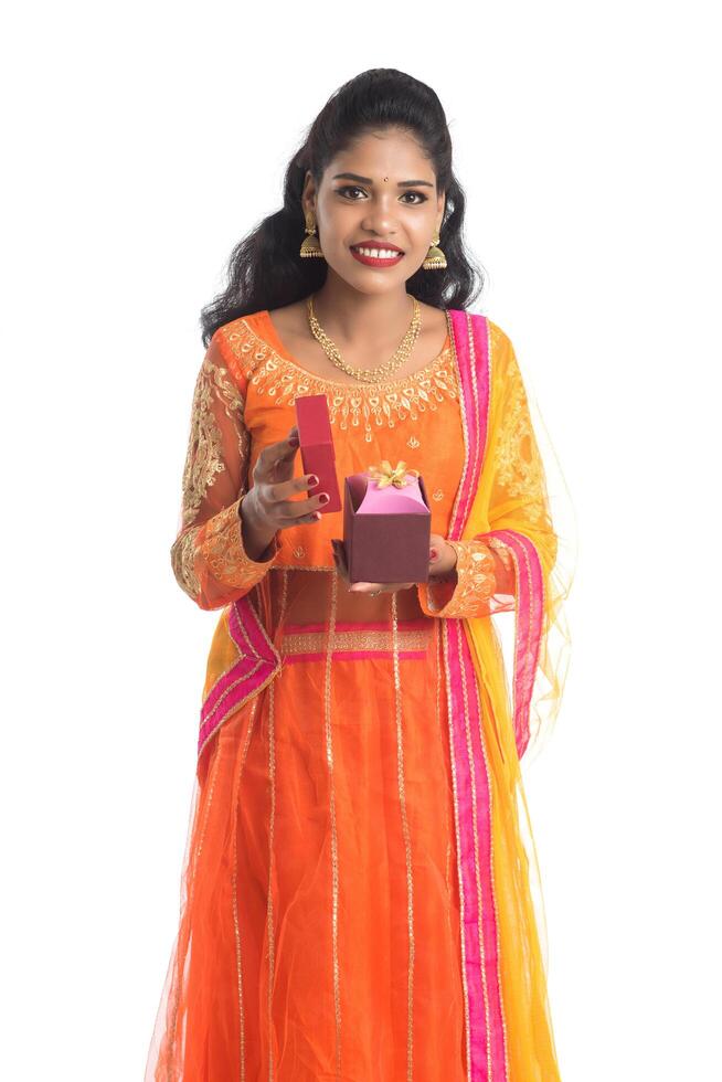 Portrait of young happy smiling Indian Girl holding gift boxes on a white background. photo