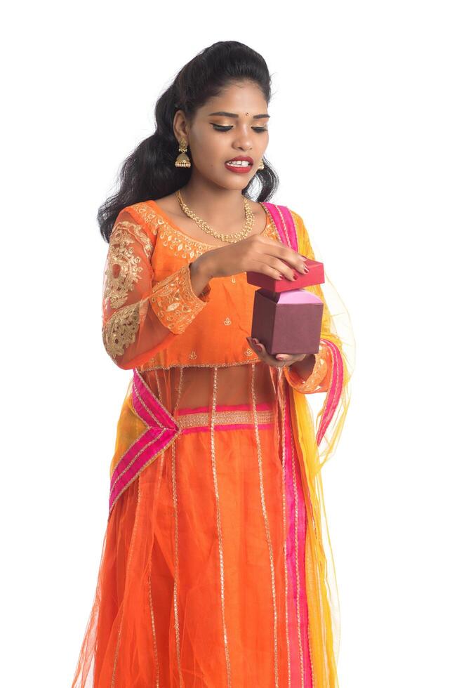 Portrait of young happy smiling Indian Girl holding gift boxes on a white background. photo