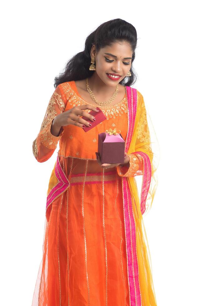 Portrait of young happy smiling Indian Girl holding gift boxes on a white background. photo