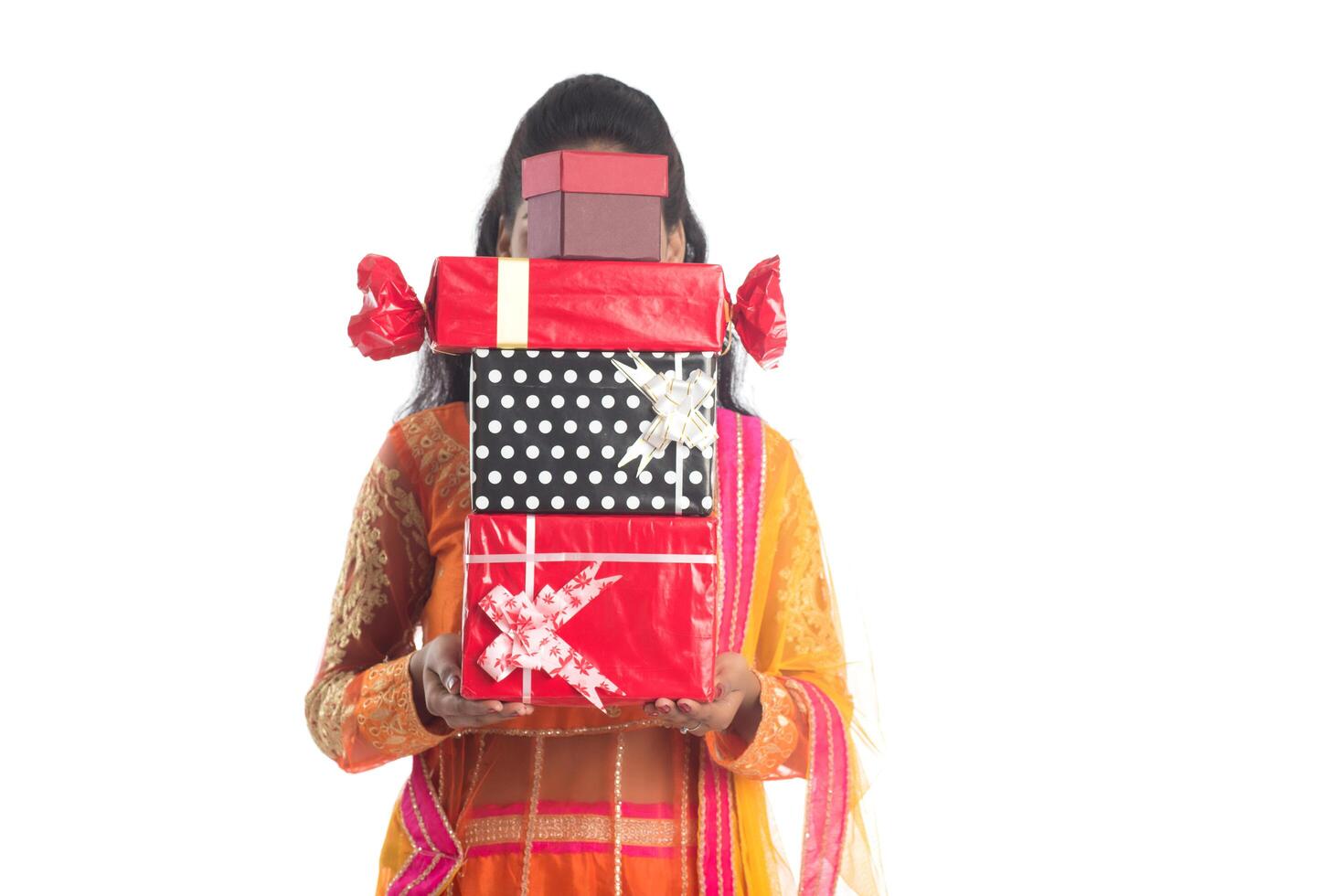 Portrait of young happy smiling Indian Girl holding gift boxes on a white background. photo