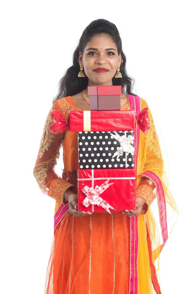 Portrait of young happy smiling Indian Girl holding gift boxes on a white background. photo