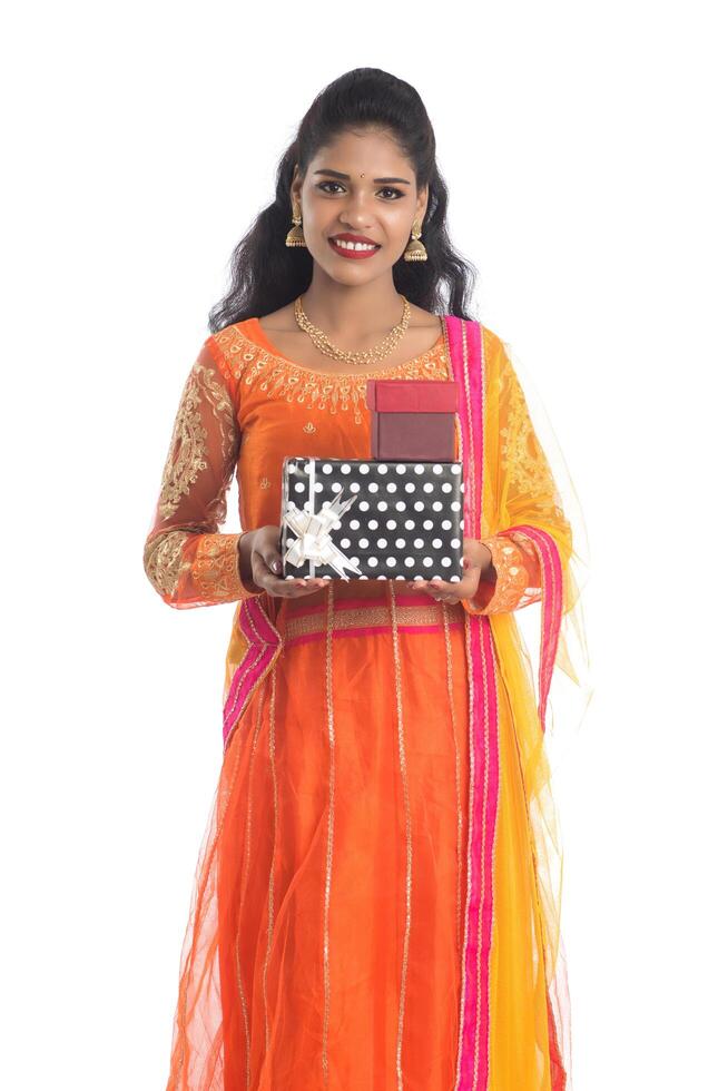 Portrait of young happy smiling Indian Girl holding gift boxes on a white background. photo