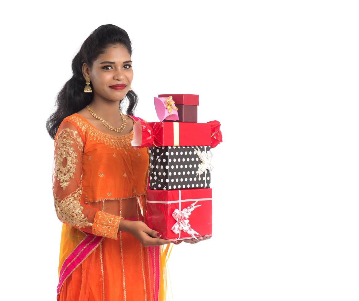 Portrait of young happy smiling Indian Girl holding gift boxes on a white background. photo