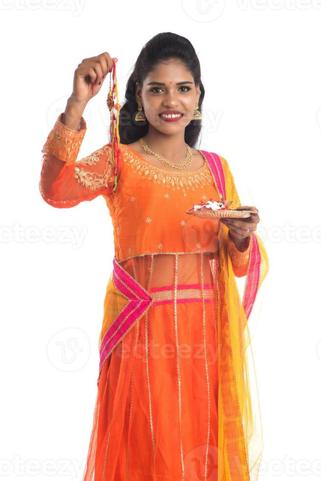 Beautiful Indian girl showing Rakhi with pooja thali on occasion of Raksha Bandhan. Sister tie Rakhi as a symbol of intense love for her brother. photo
