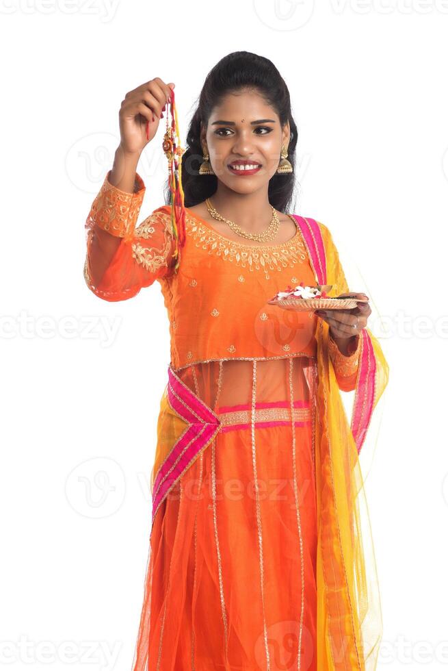 Beautiful Indian girl showing Rakhi with pooja thali on occasion of Raksha Bandhan. Sister tie Rakhi as a symbol of intense love for her brother. photo