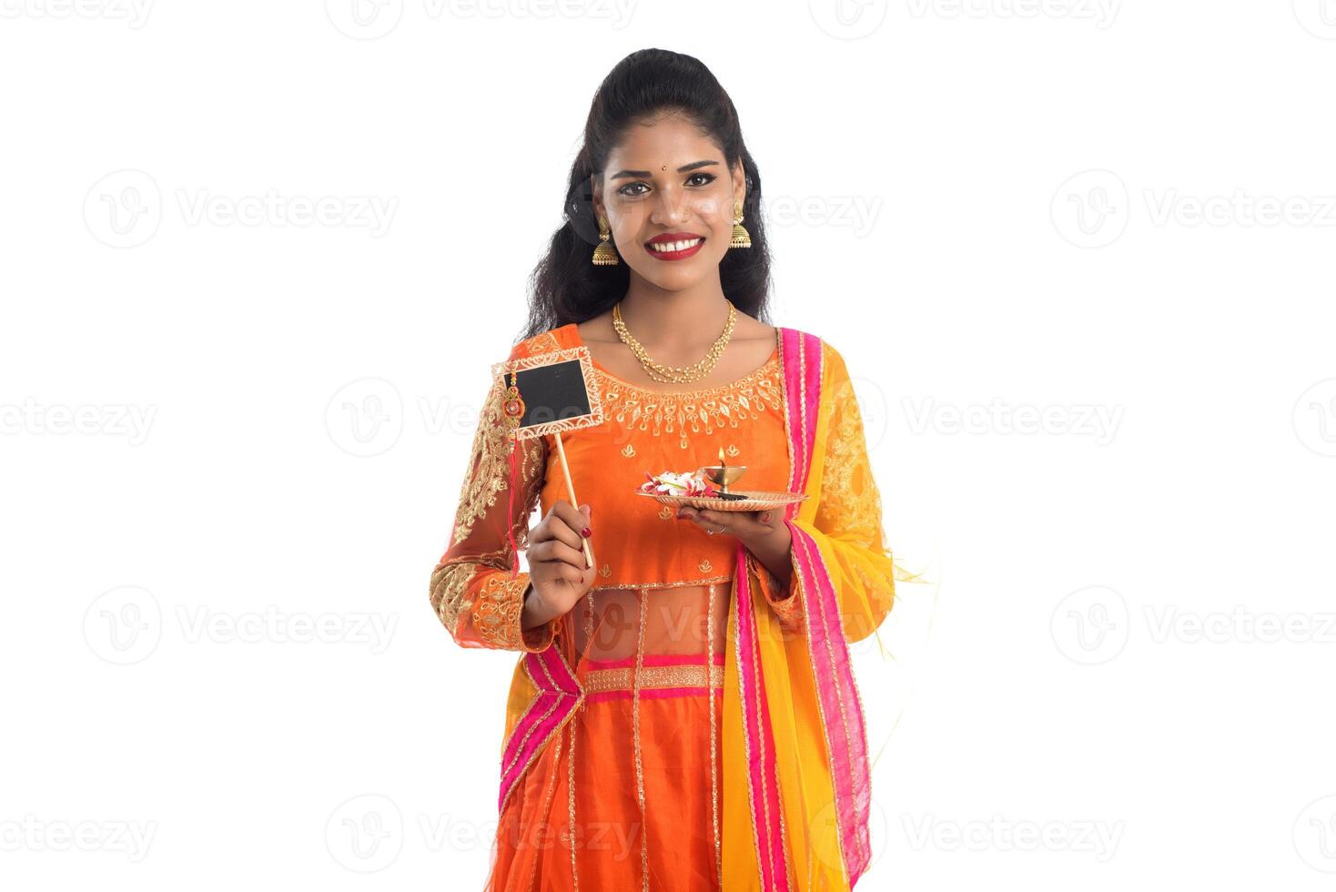 Beautiful Indian girl showing Rakhi on occasion of Raksha Bandhan with pooja thali and black board. Sister tie Rakhi as a symbol of intense love for her brother. photo